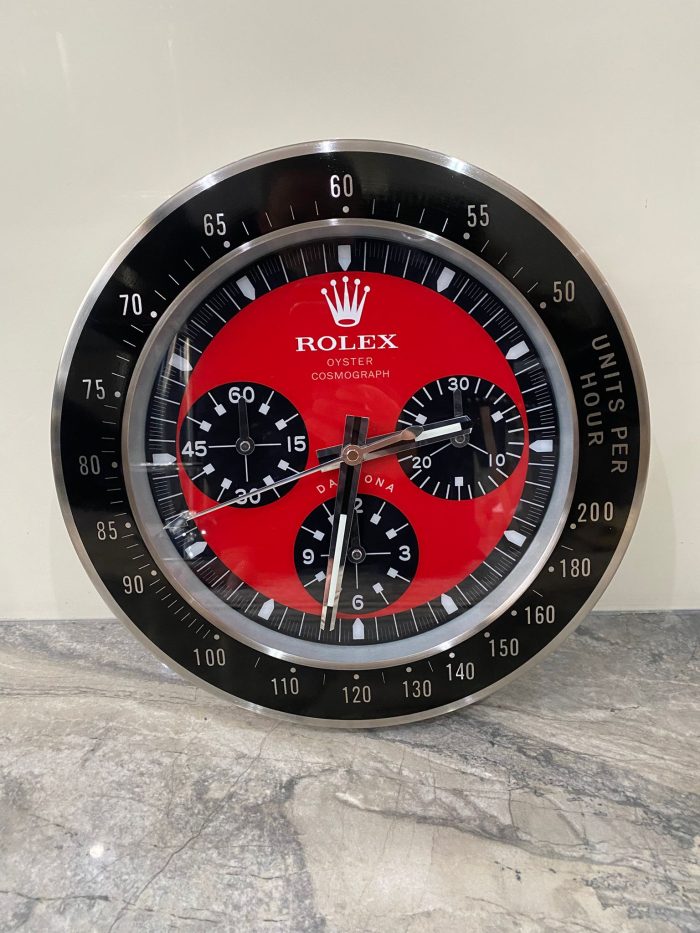 DAYTONA Wall Clock stainless steel with black bezel and red face.