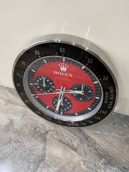 DAYTONA Wall Clock stainless steel with black bezel and red face.