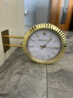 Rolex Datejust luxury wall clock mounted on white wall with premium gold wall bracket